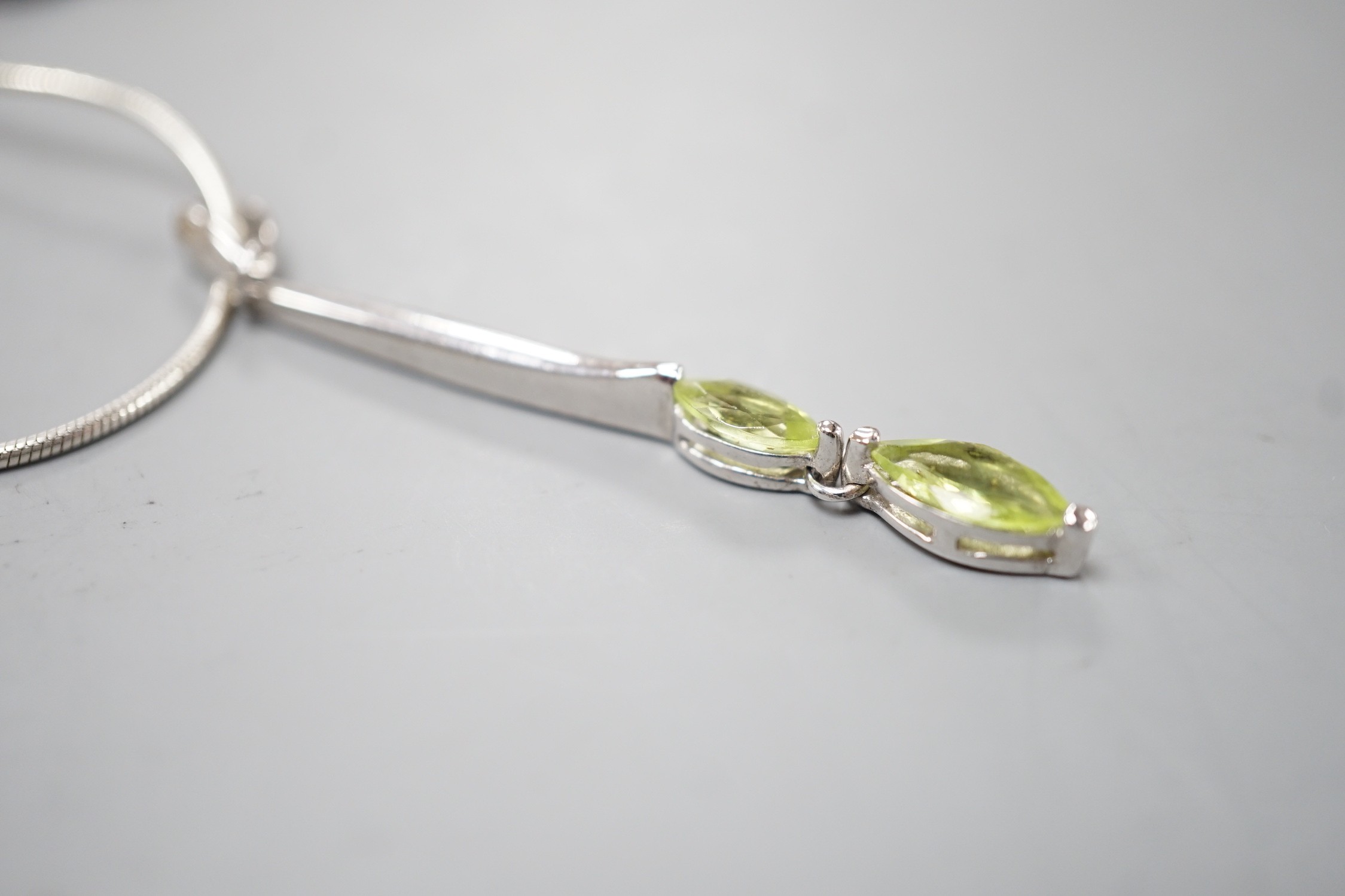 A modern 925 and two stone peridot set pendant,53mm, on a 925 chain, 42cm.